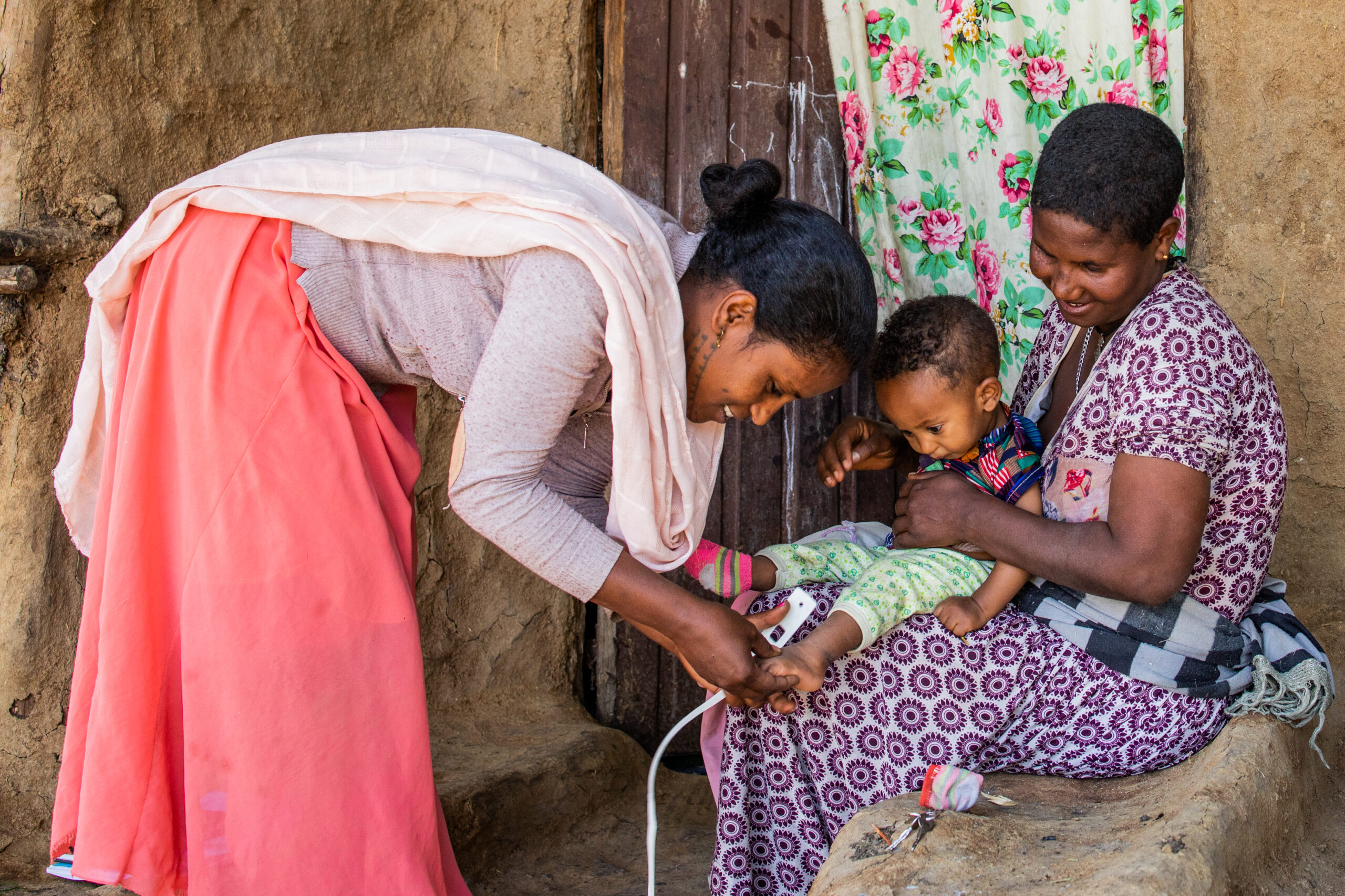 A Health Extension Worker measures a child's growth at a village home in Ethiopia
