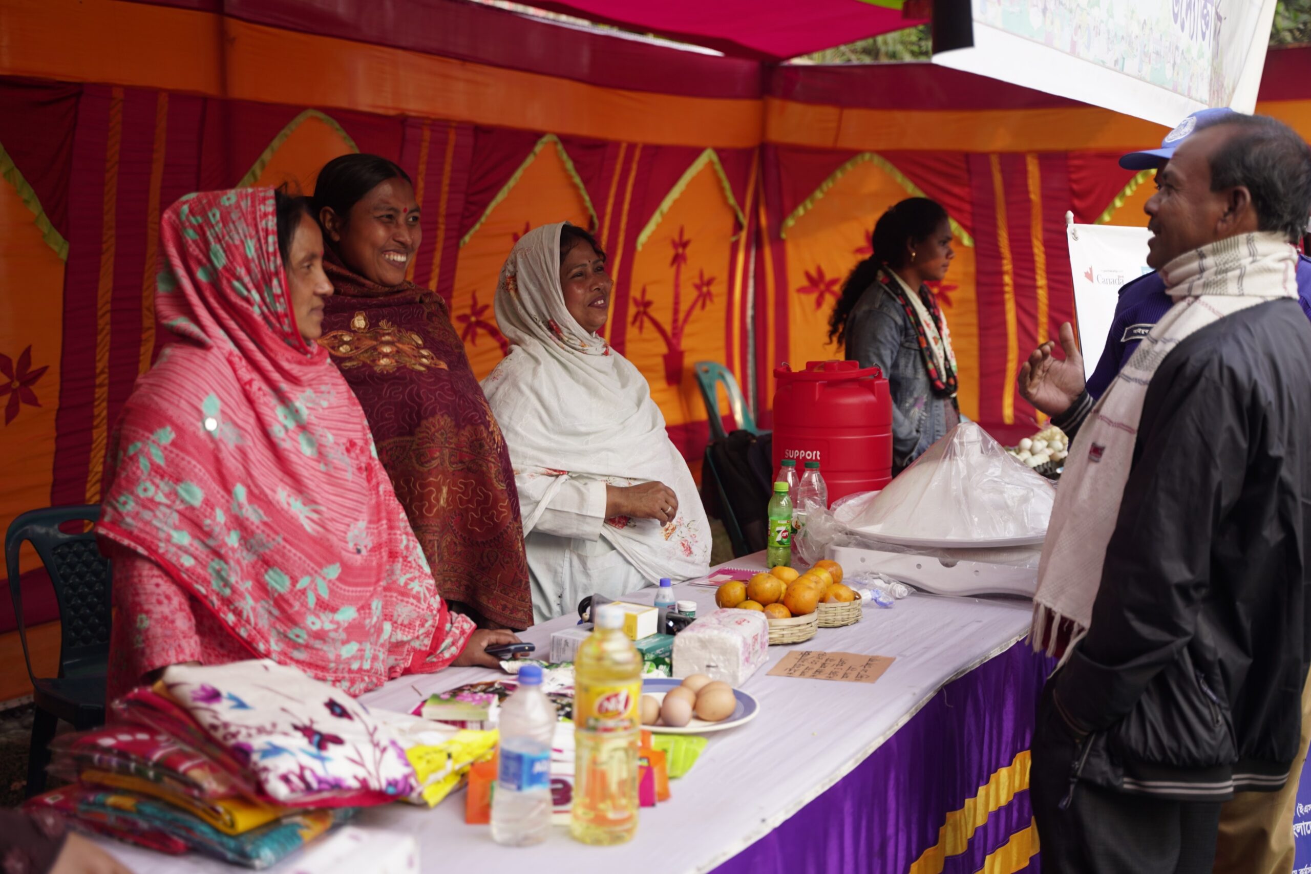 Lata Debi showcasing health and nutrition products alongside other entrepreneurs during a community campaign in Lalmonirhat, Bangladesh