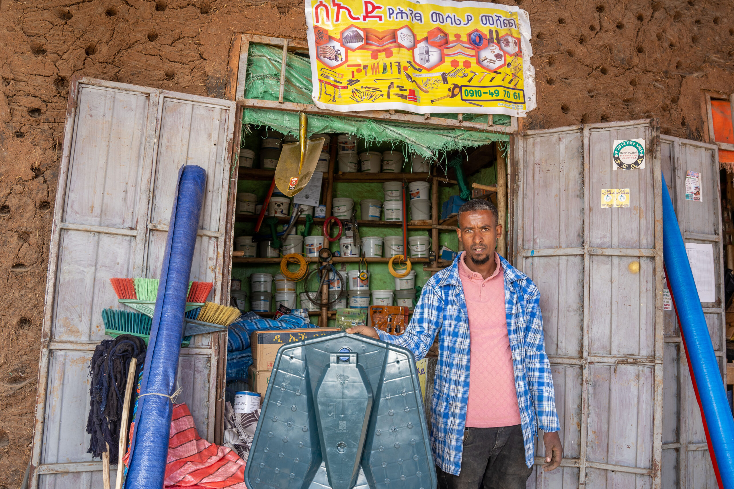 A sanitation entrepreneur displays latrine materials and tools at his shop in Ethiopia